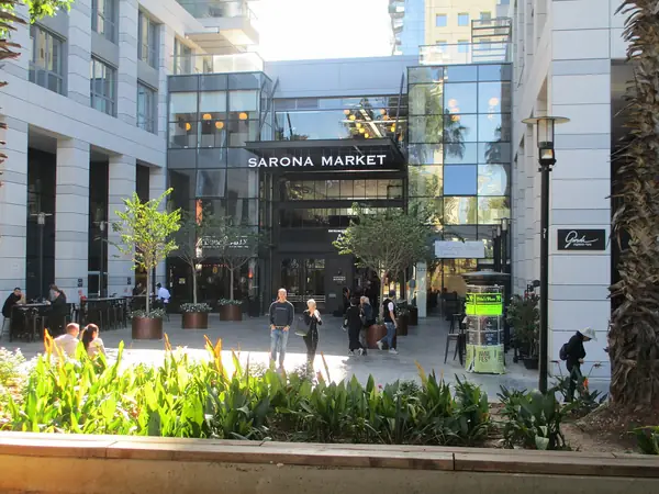 People and planters outside the entrance to Sarona Market in the restored Sarona colony, Tel Aviv