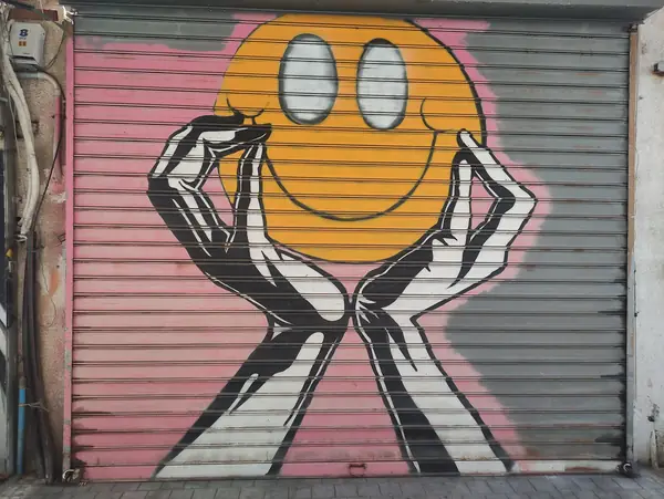 A smiley-face graffiti piece on a shop shutter in the Noga flea-market lanes of Jaffa