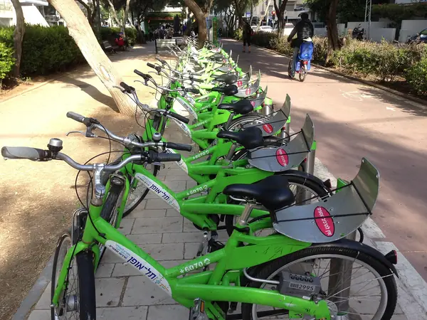 A row of green bike-share cycles beside the Ben Gurion Boulevard path in the Old North